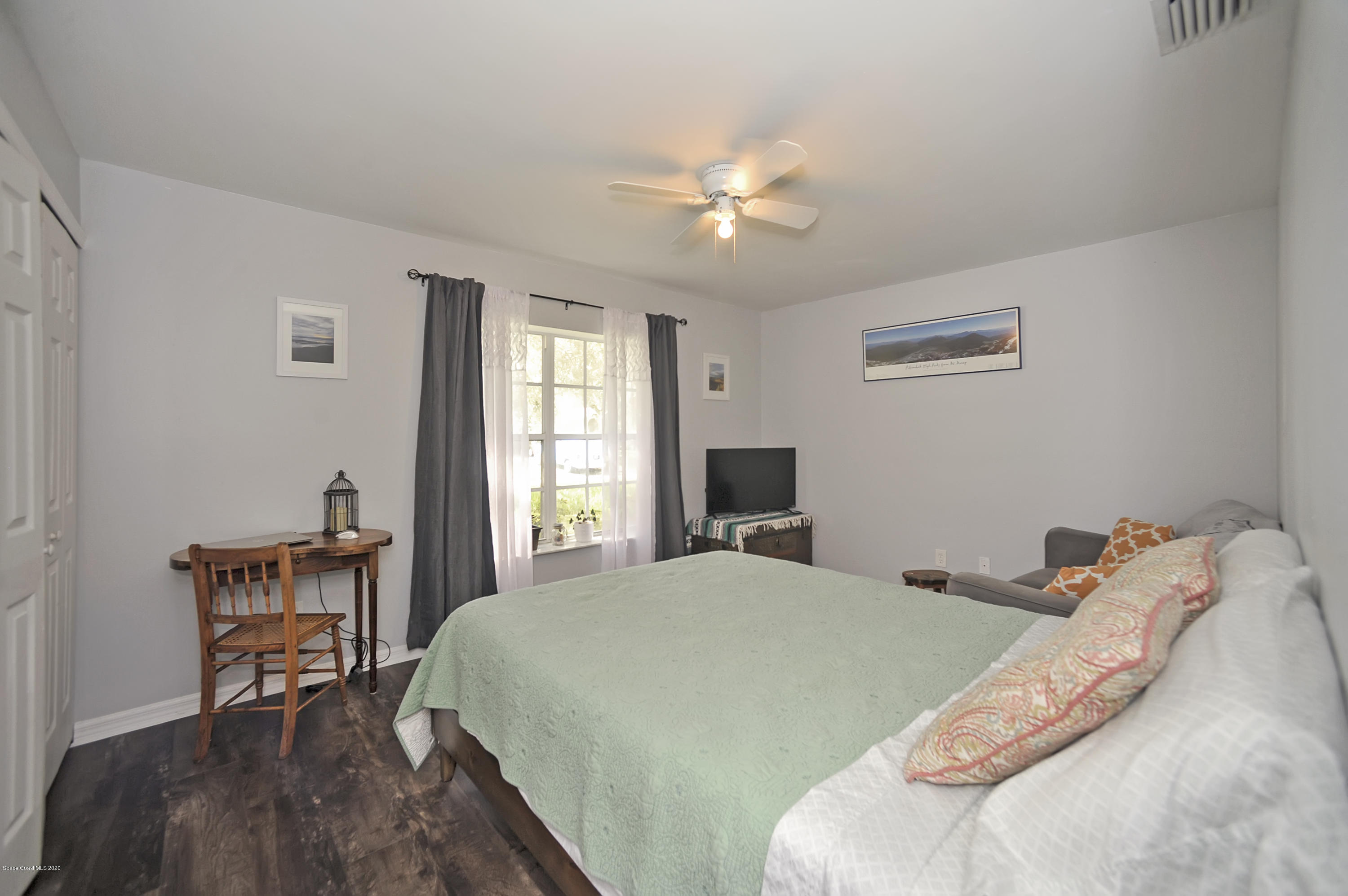 877 Walpole Road Southwest Palm Bay, FL 32908 - Photo 18 of 27 a bedroom with a bed and a chandelier