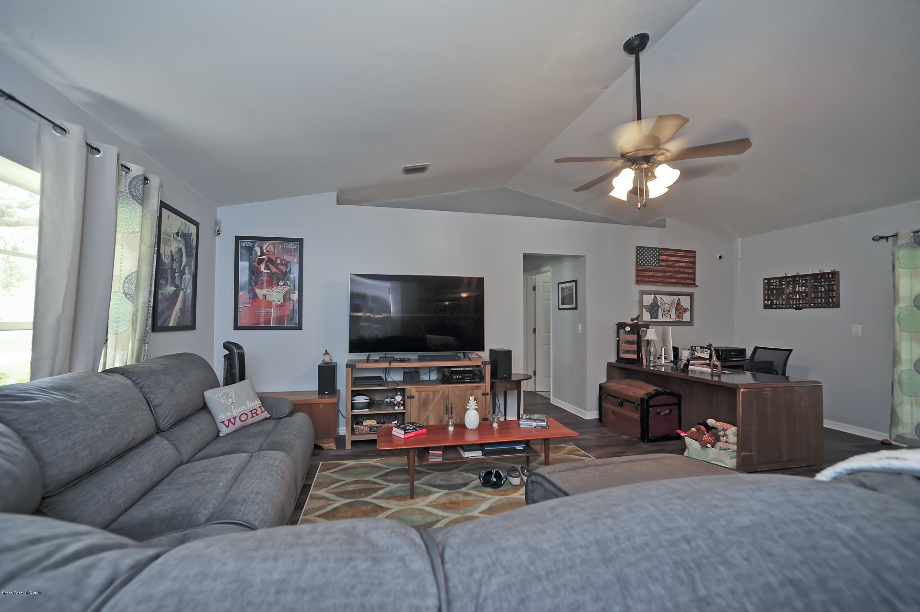 877 Walpole Road Southwest Palm Bay, FL 32908 - Photo 6 of 27 a living room with furniture and a flat screen tv
