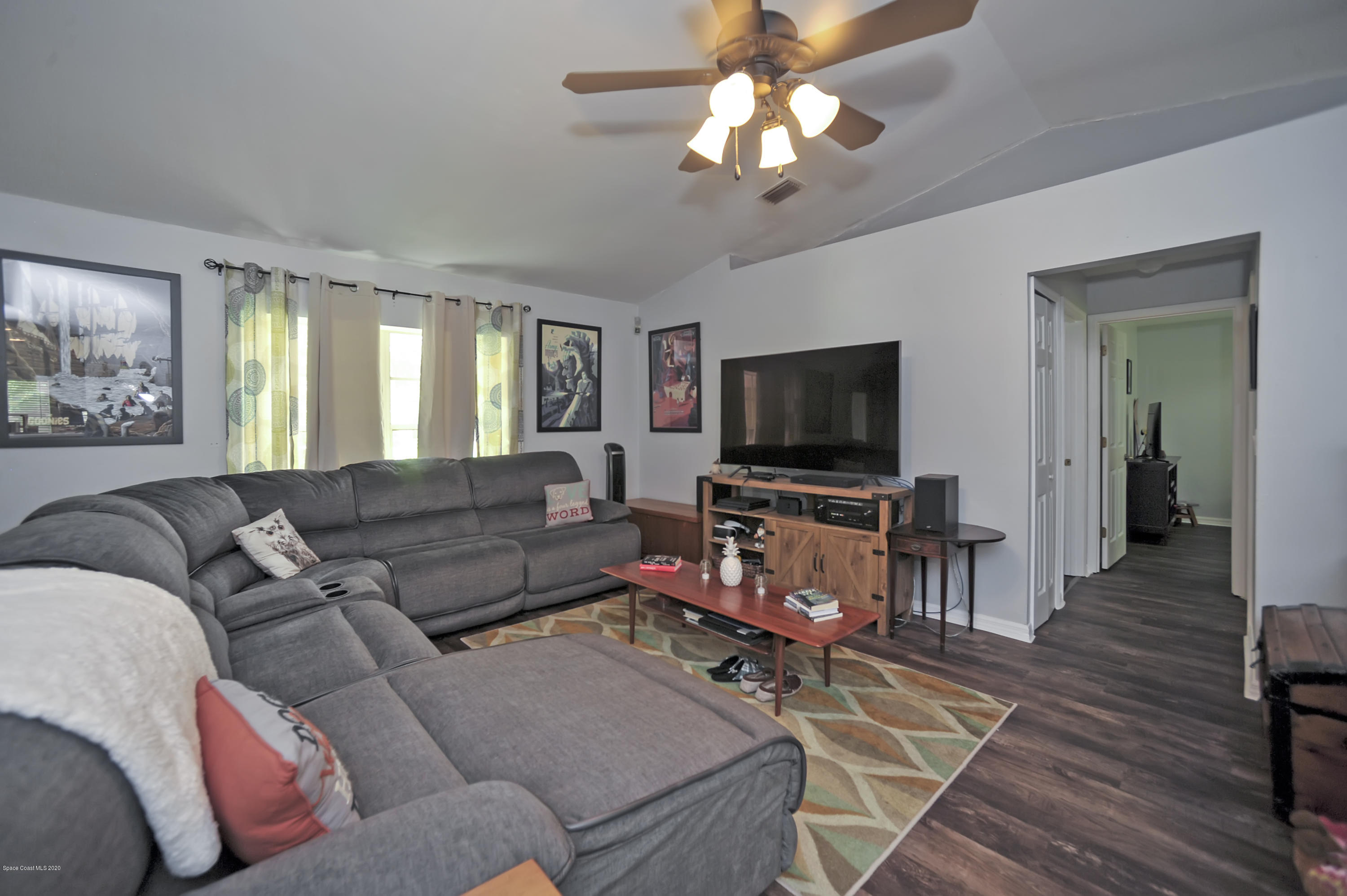 877 Walpole Road Southwest Palm Bay, FL 32908 - Photo 8 of 27 a living room with furniture and a flat screen tv