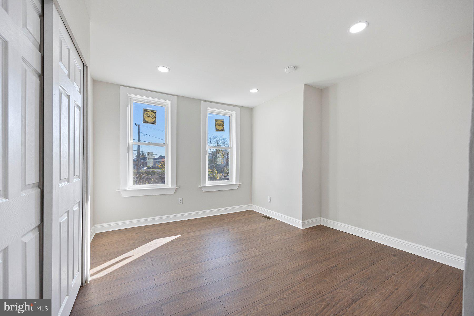 117 Collins Avenue Baltimore, MD 21229 - Photo 12 of 27 an empty room with wooden floor and windows