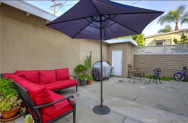 a patio with a table and chairs under an umbrella