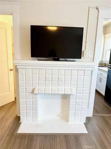 a living room with wooden floor and flat screen tv