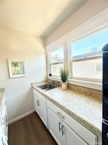 a bathroom with a granite countertop sink and a window