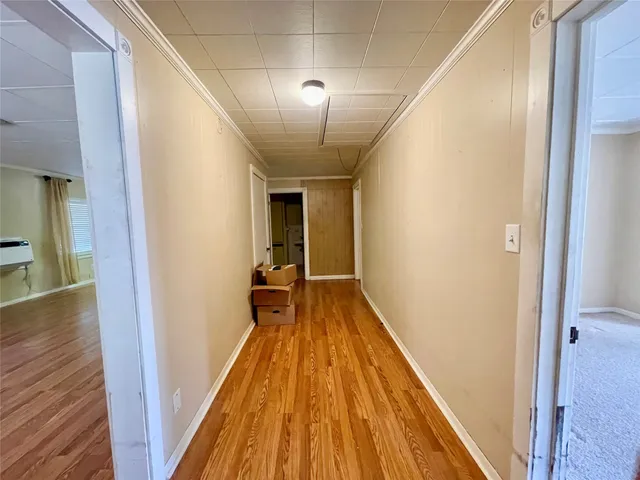 a view of a hallway with wooden floor and staircase