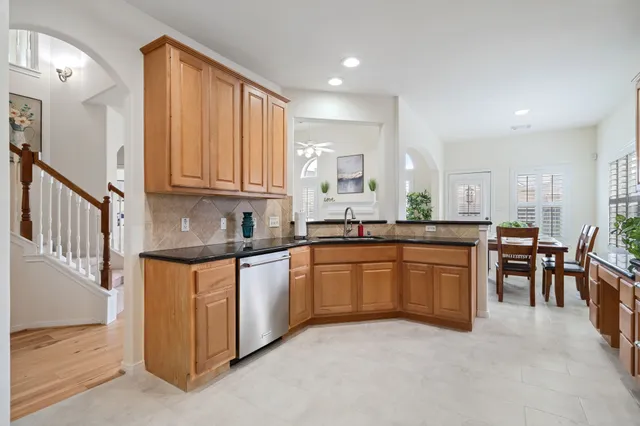 a large kitchen with granite countertop lots of counter space and windows