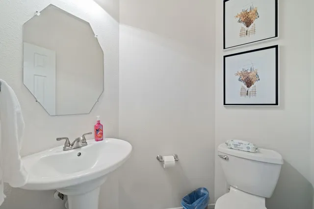a bathroom with a sink mirror and toilet