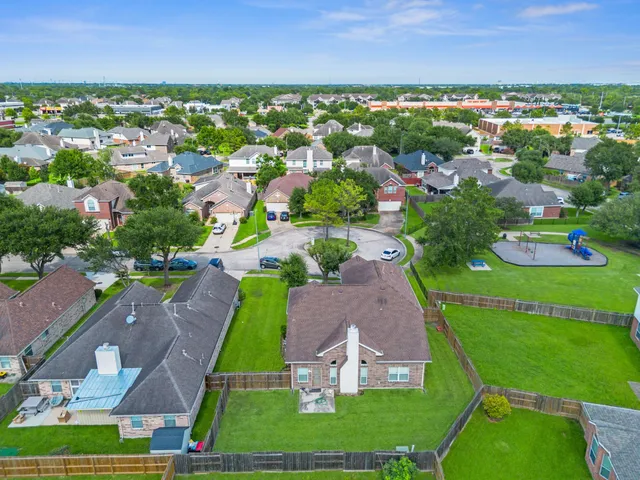 an aerial view of a city with lots of residential buildings ocean and mountain view in back