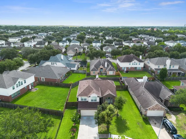 an aerial view of a city with lots of residential buildings ocean and mountain view in back