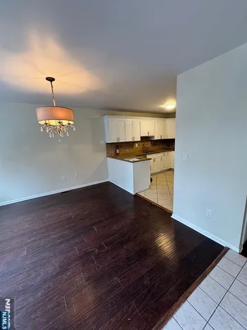 a kitchen with a stove and wooden floor