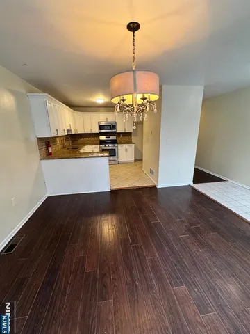 a view of a kitchen with a sink wooden floor and a large window