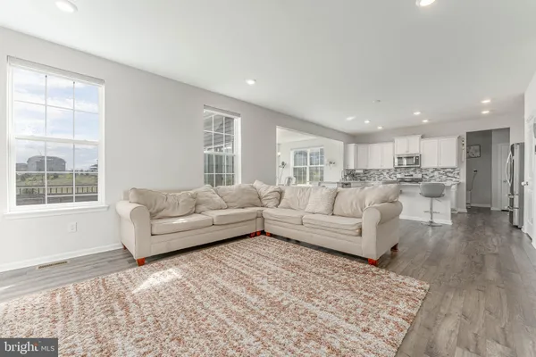 a kitchen with stainless steel appliances kitchen island hardwood floor and a sink