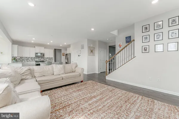 a kitchen with stainless steel appliances a refrigerator a stove a sink dishwasher and a dining table with wooden floor