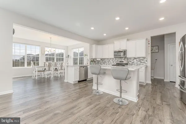 a kitchen with white cabinets and refrigerator