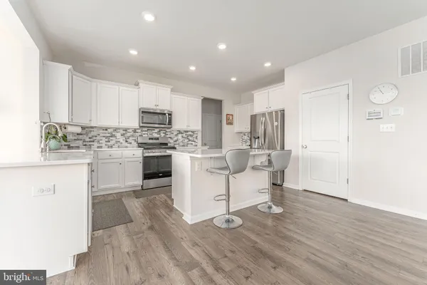 a kitchen with white cabinets and counter space