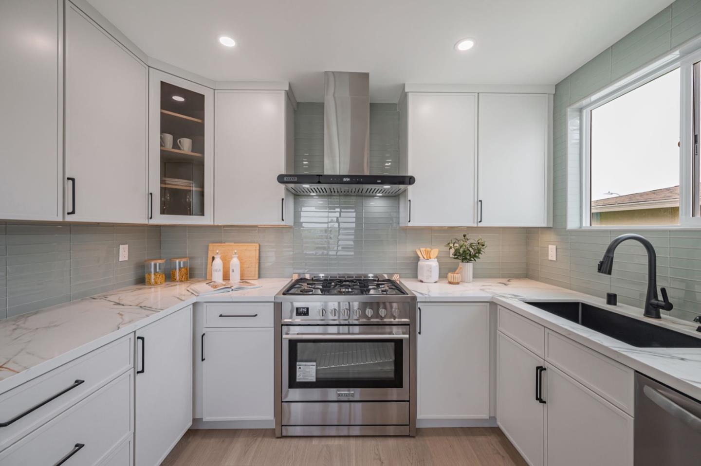 443 Andover Drive Pacifica, CA 94044 - Photo 18 of 56 a kitchen with granite countertop white cabinets and stainless steel appliances