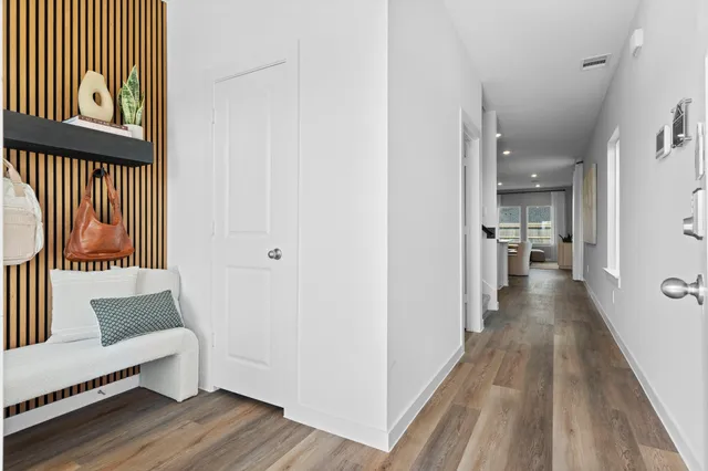 a view of a hallway with wooden floor and furniture