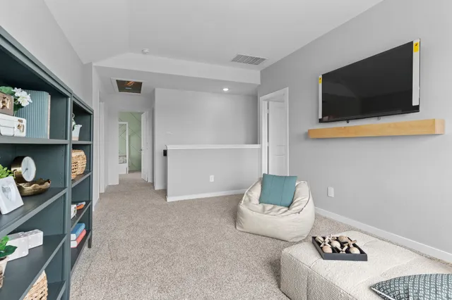 a living room with a flat screen tv and view of kitchen