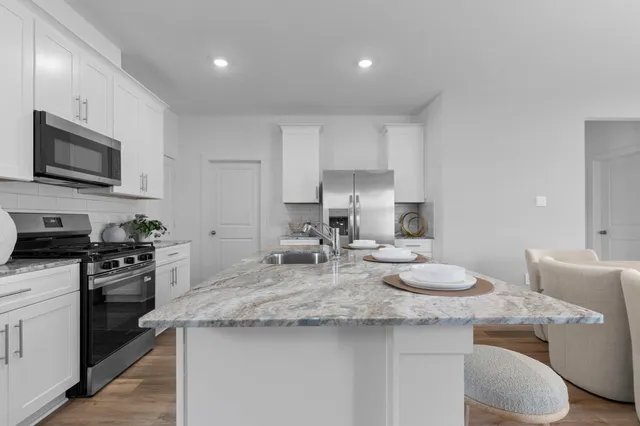 a kitchen with sink stove top oven and microwave