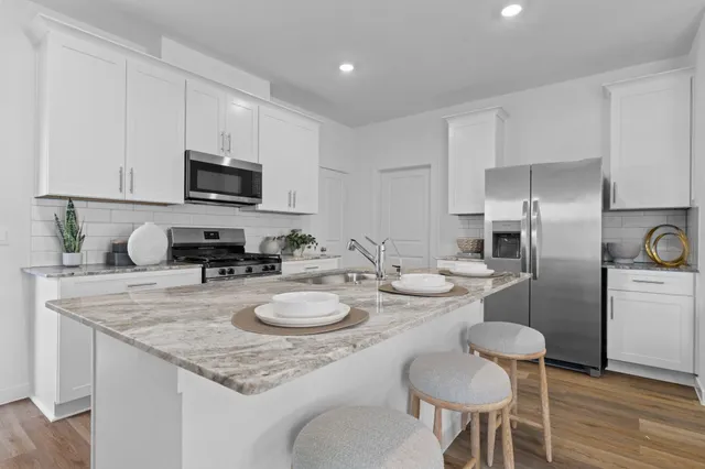 a kitchen with sink cabinets stainless steel appliances and dining table