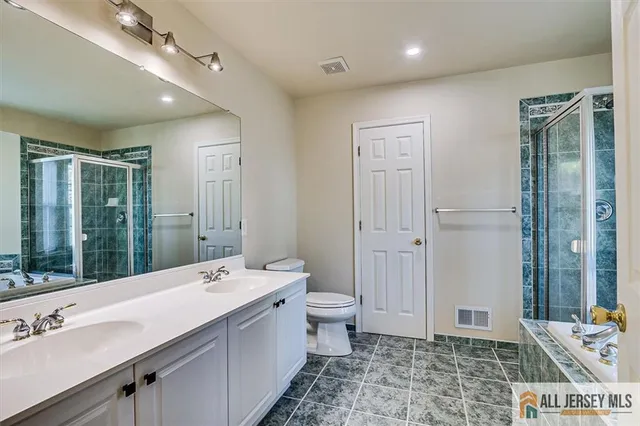 a bathroom with a sink double vanity granite and a shower