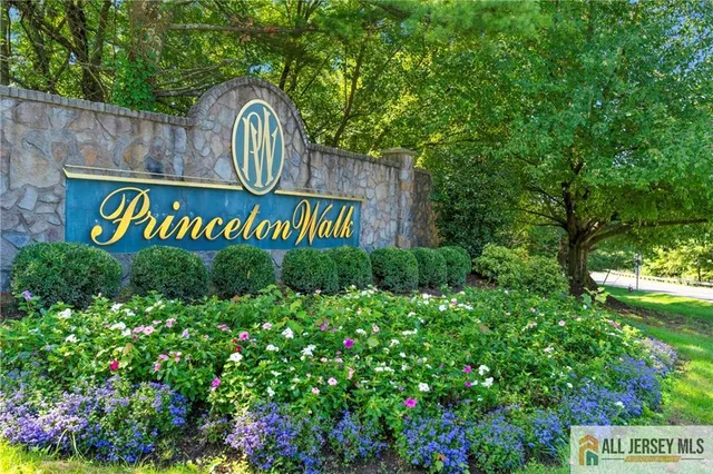 a view of sign board with plants in the background