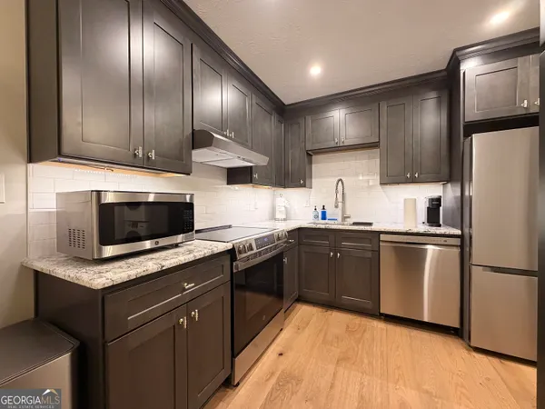 a kitchen with granite countertop stainless steel appliances and wooden cabinets