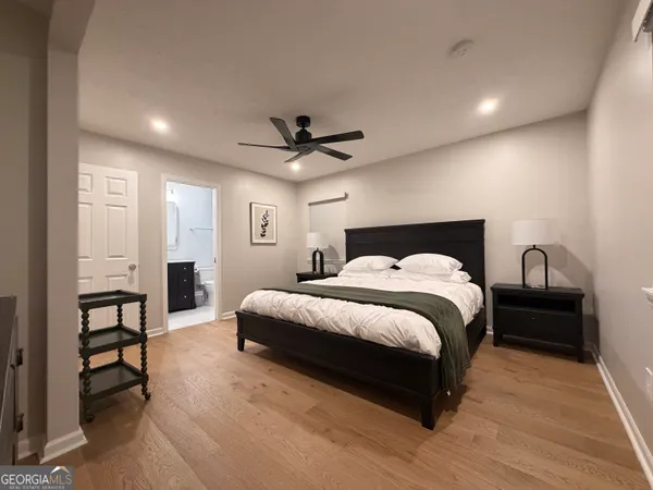 a spacious bedroom with a bed a table and a chandelier