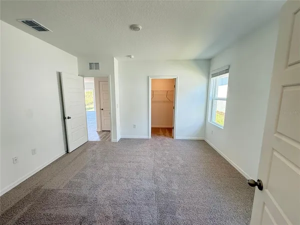 an empty room with closet and windows