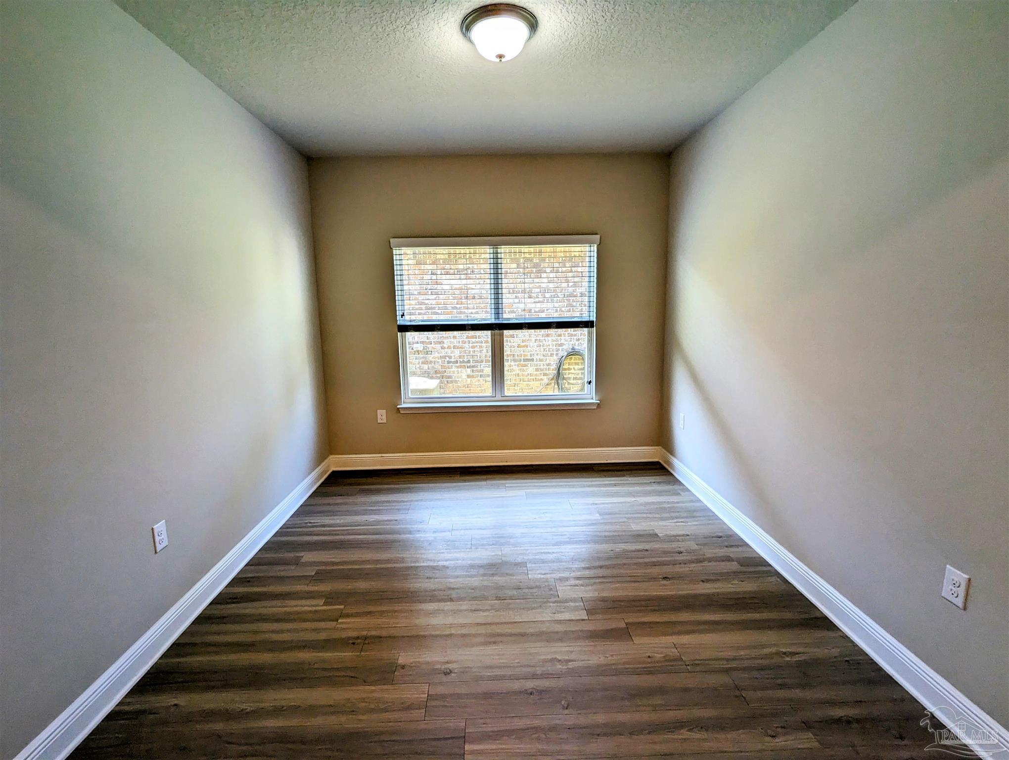 5348 Red Shoulder Road Pace, FL 32571 - Photo 12 of 39 a view of an empty room with wooden floor and a window