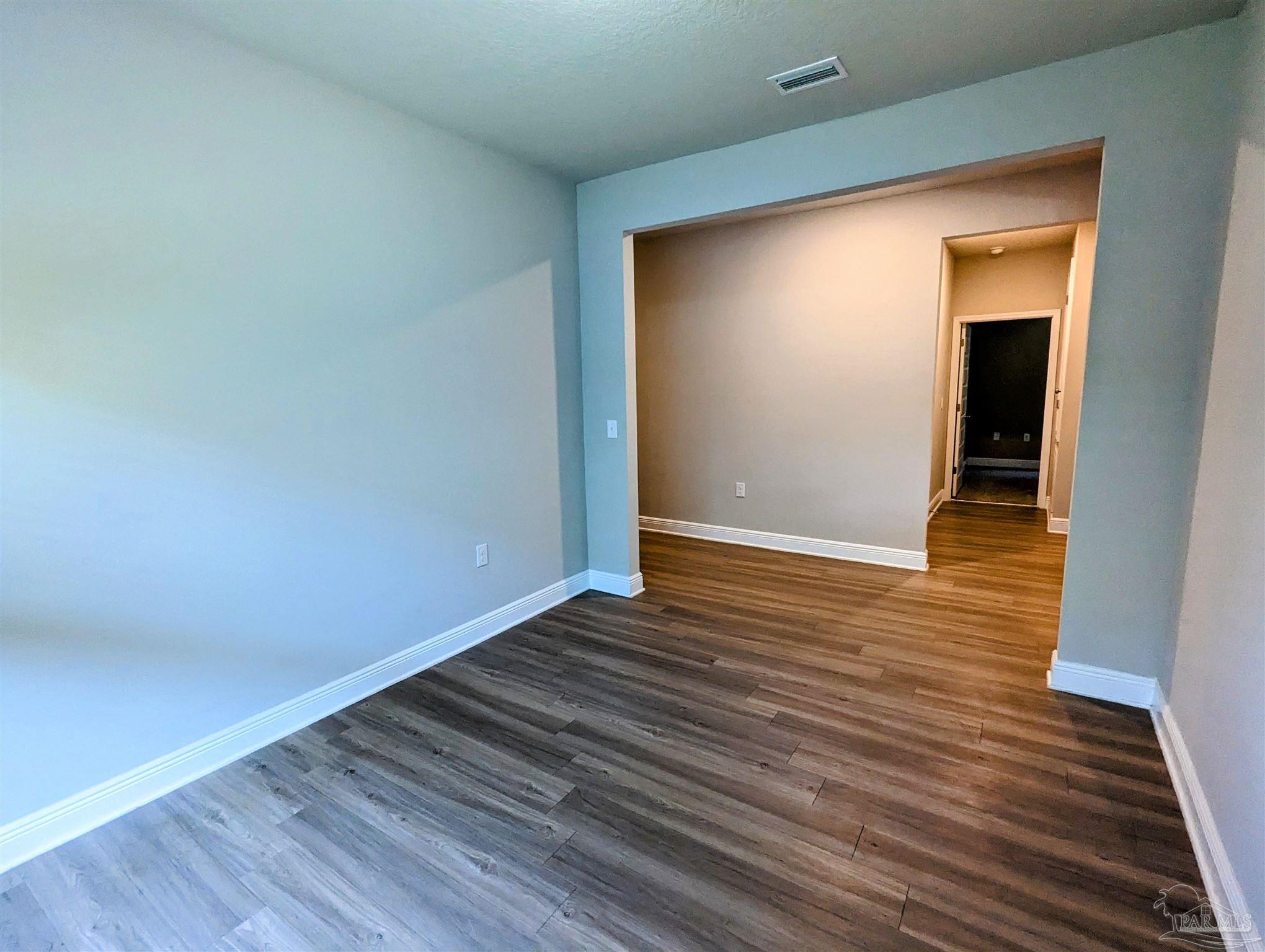 5348 Red Shoulder Road Pace, FL 32571 - Photo 14 of 39 a view of an empty room with wooden floor and closet