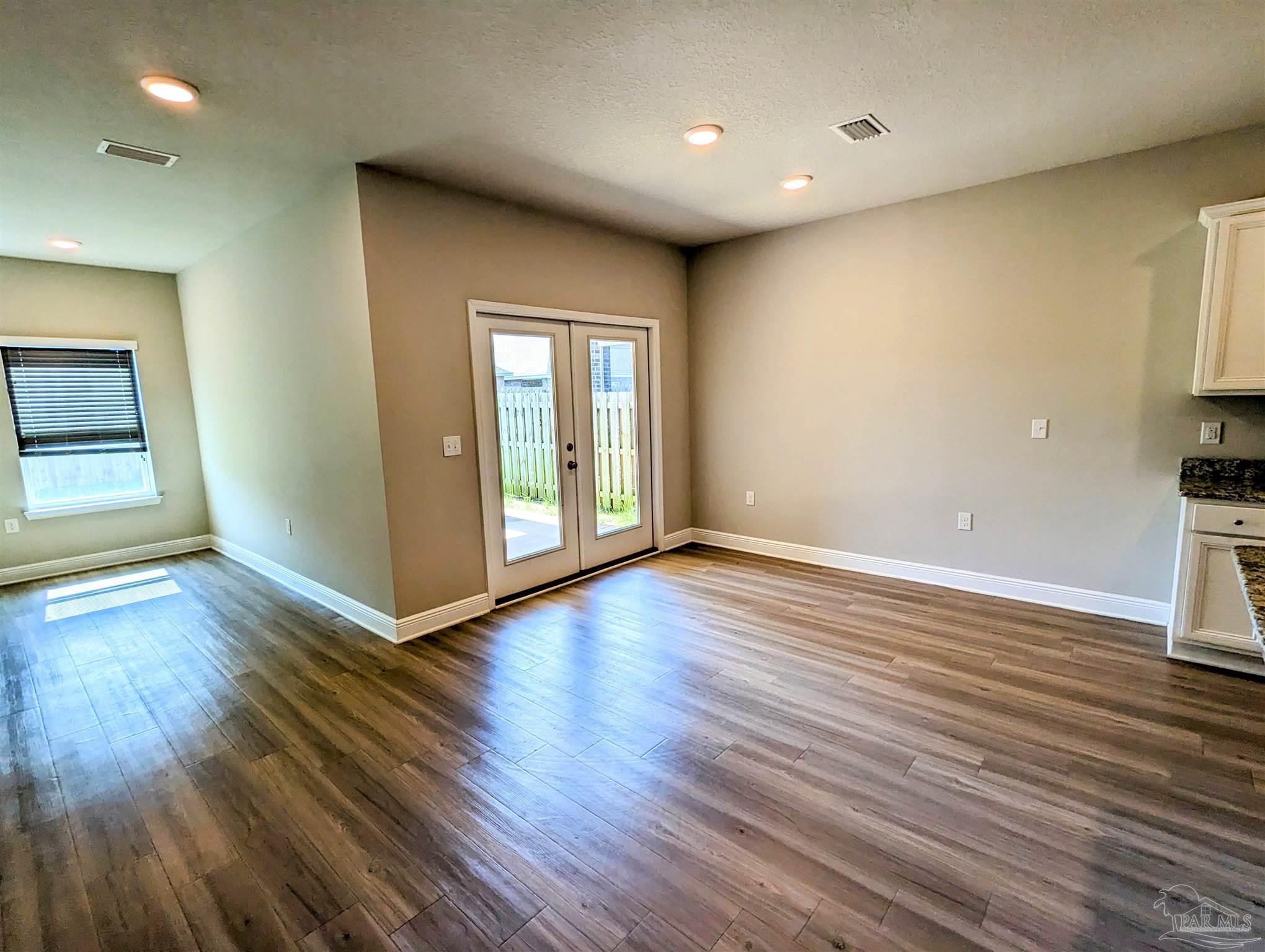 5348 Red Shoulder Road Pace, FL 32571 - Photo 23 of 39 an empty room with wooden floor and windows