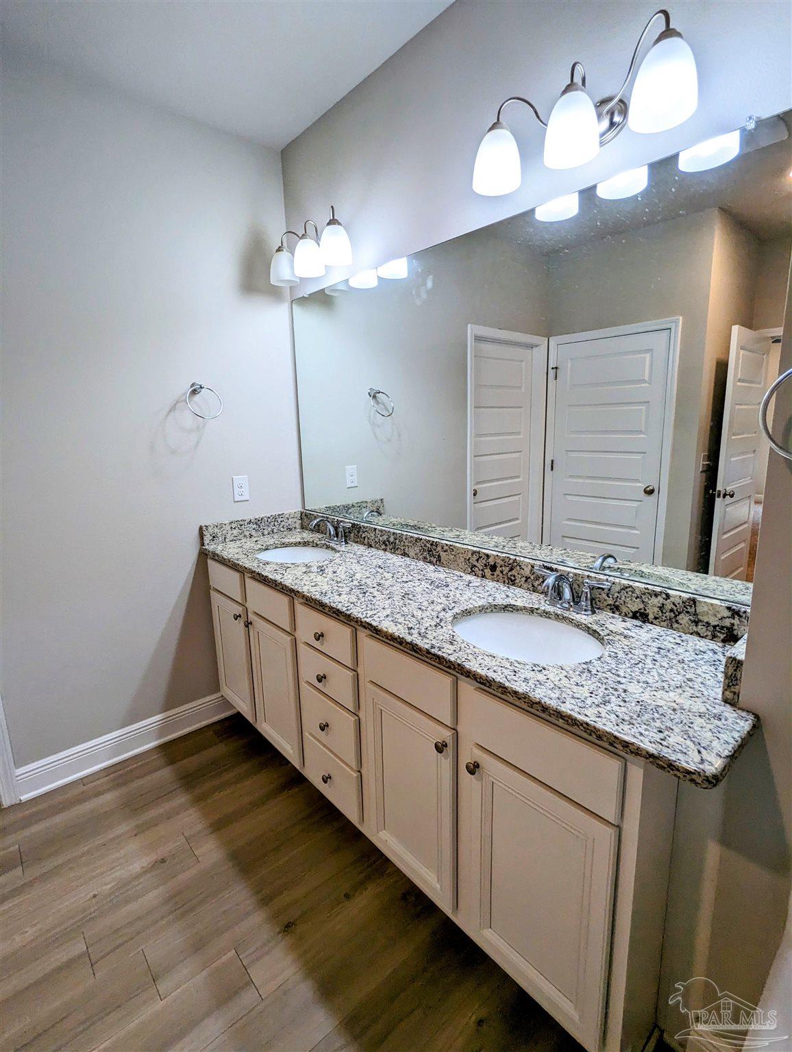 5348 Red Shoulder Road Pace, FL 32571 - Photo 32 of 39 a bathroom with a granite countertop sink a light fixture and a mirror