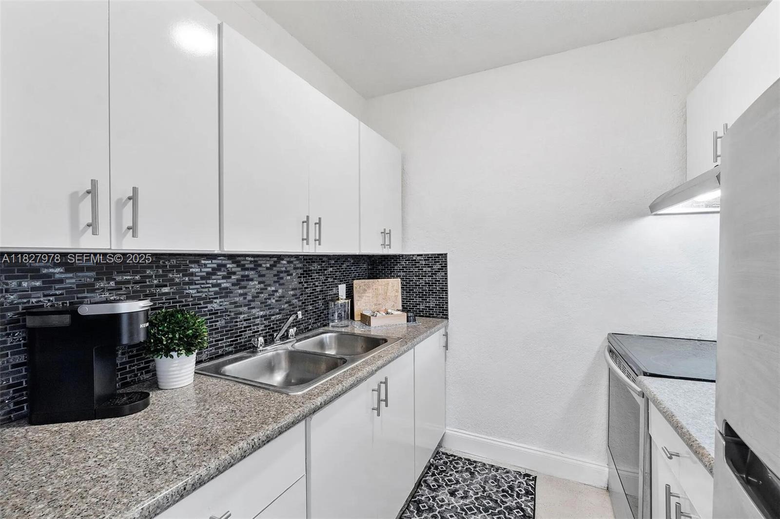 1401 Northwest 103rd Street, Unit 139 Miami, FL 33147 - Photo 3 of 11 a kitchen with a sink and cabinets