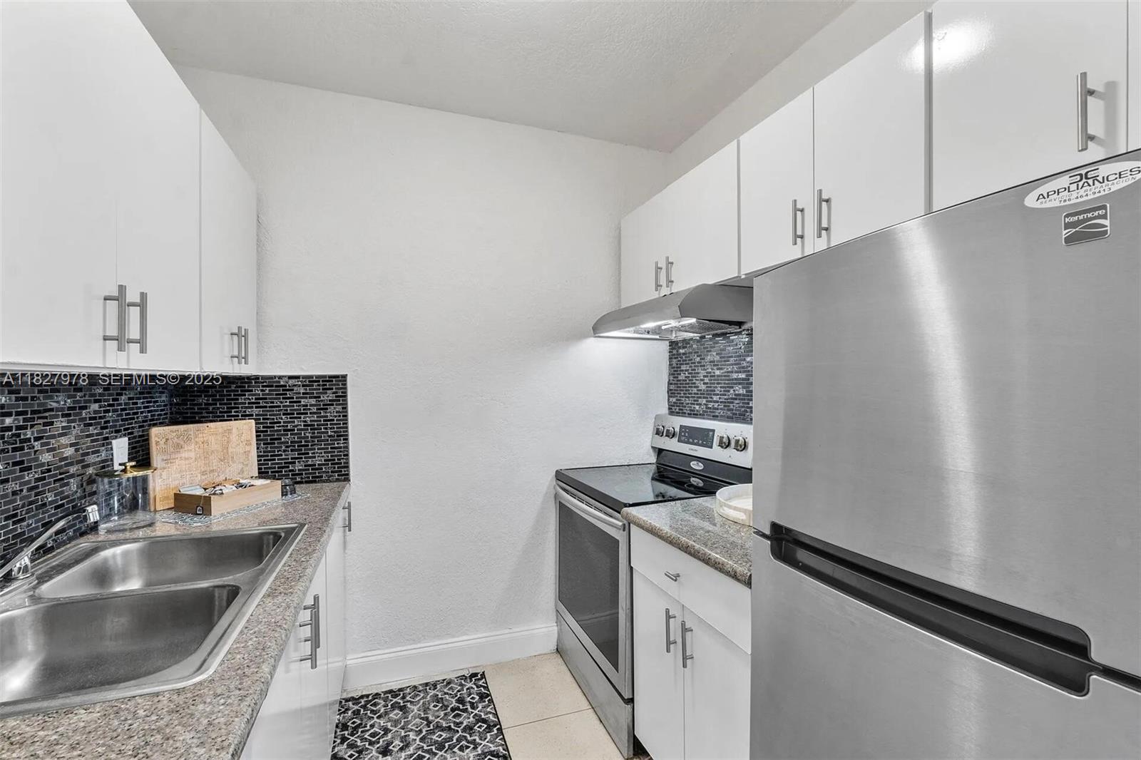 1401 Northwest 103rd Street, Unit 139 Miami, FL 33147 - Photo 4 of 11 a kitchen with granite countertop a sink stove and refrigerator