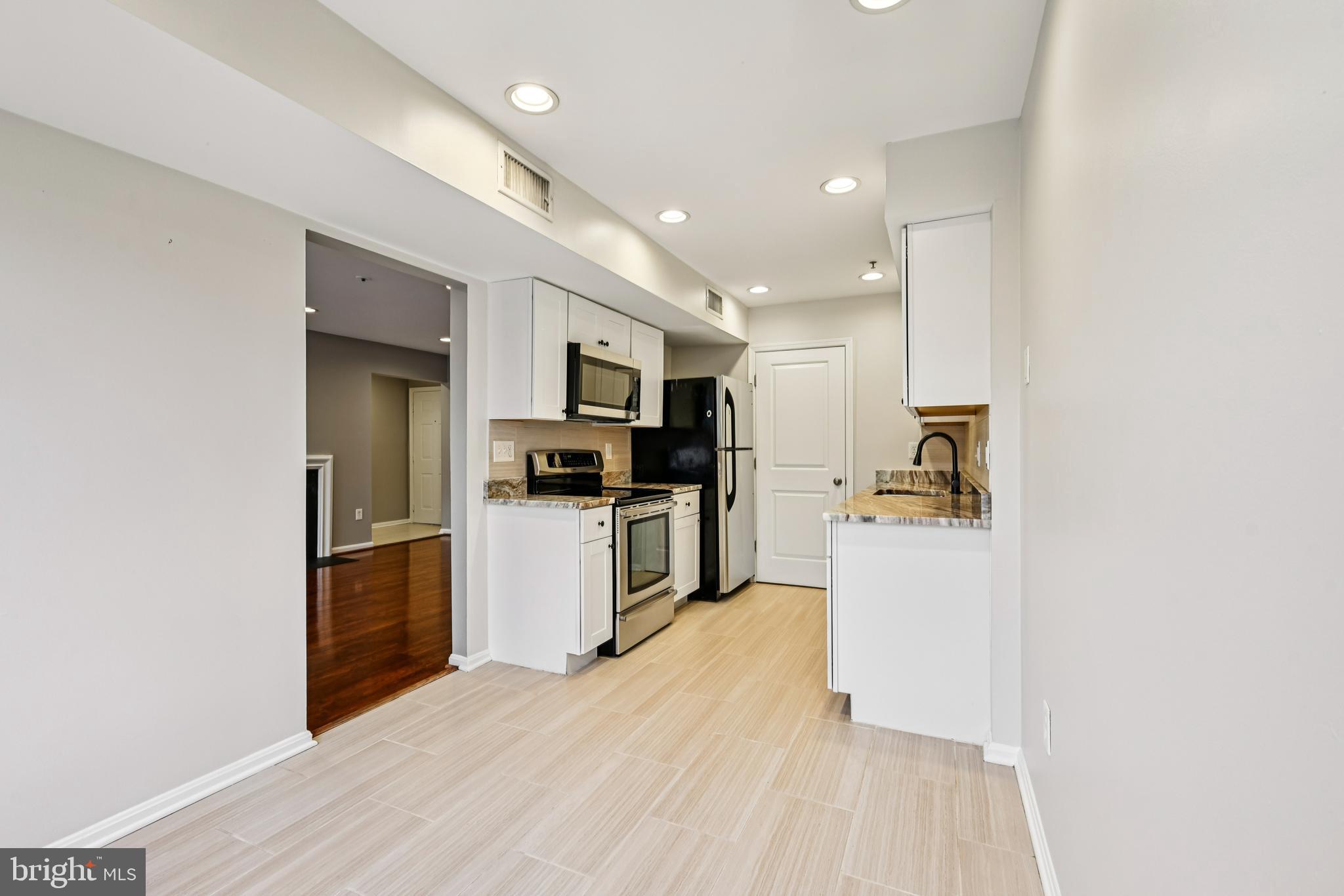 14901 Cleese Court, Unit 5CE Silver Spring, MD 20906 - Photo 11 of 25 a kitchen with white cabinets and stainless steel appliances