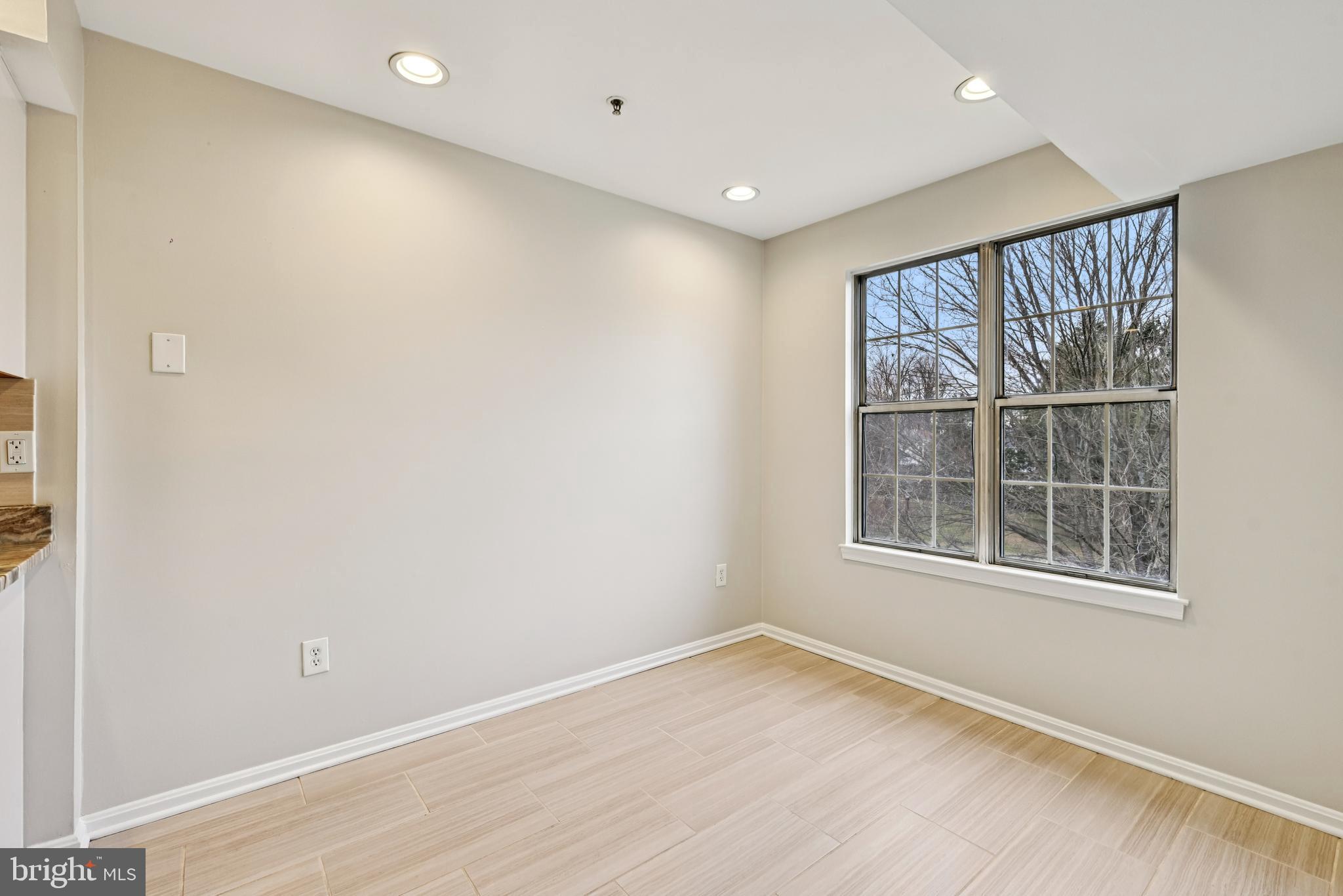 14901 Cleese Court, Unit 5CE Silver Spring, MD 20906 - Photo 13 of 25 an empty room with wooden floor and windows