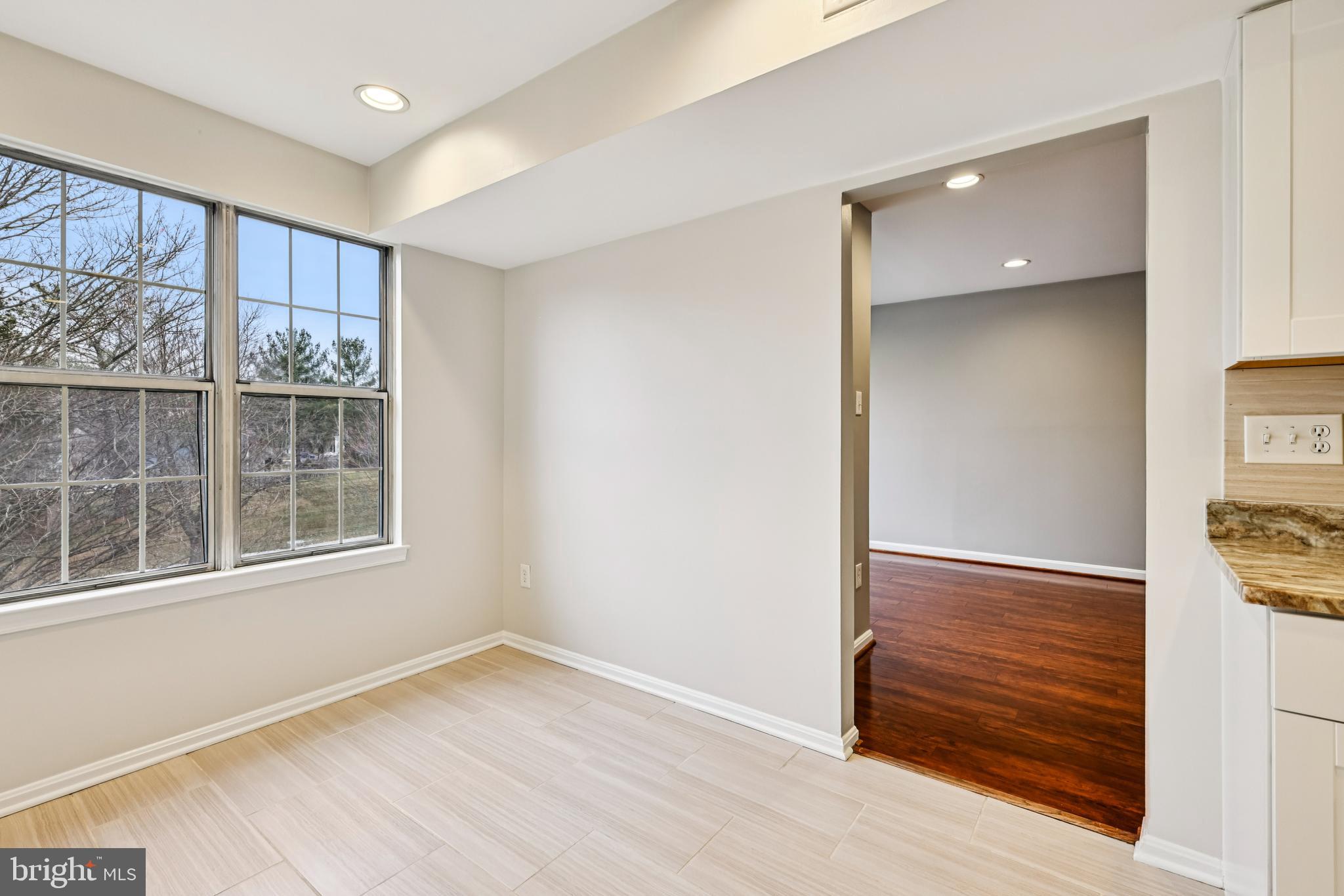 14901 Cleese Court, Unit 5CE Silver Spring, MD 20906 - Photo 14 of 25 an empty room with wooden floor cabinet and windows