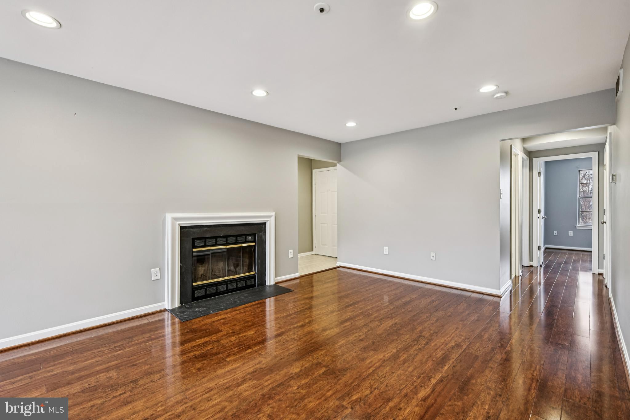 14901 Cleese Court, Unit 5CE Silver Spring, MD 20906 - Photo 5 of 25 a view of an empty room with wooden floor fireplace and a window