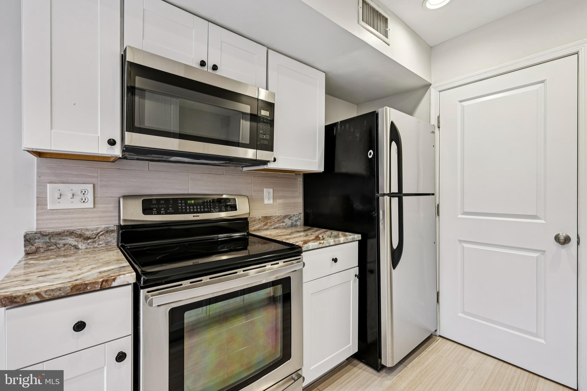 14901 Cleese Court, Unit 5CE Silver Spring, MD 20906 - Photo 8 of 25 a kitchen with a refrigerator stove and microwave