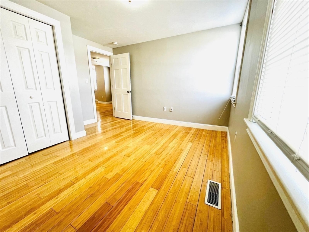 199 Andover Street, Unit 1 Andover, MA 01810 - Photo 8 of 16 a view of an empty room with wooden floor and door