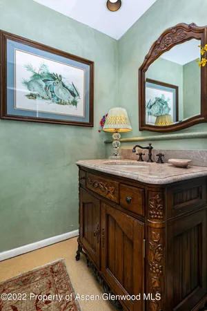a bathroom with a sink a mirror and a painting on the wall