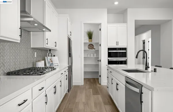 a kitchen with granite countertop a sink stove and cabinets