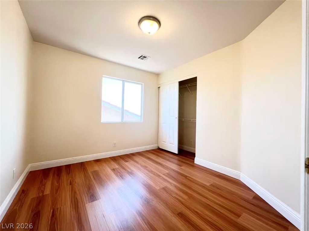 9891 Ridge Hill Avenue Las Vegas, NV 89147 - Photo 19 of 29 Rich hardwood-style flooring extends across this naturally illuminated, uncluttered bedroom space.