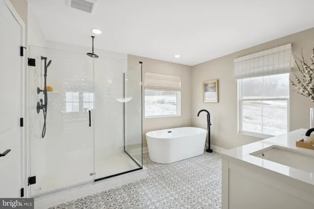 a bedroom with two beds and a large mirror next to a window