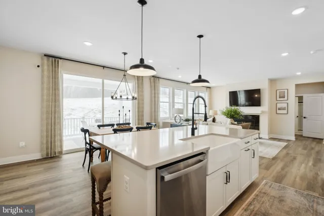 a kitchen with stainless steel appliances granite countertop a sink a stove a refrigerator and chairs