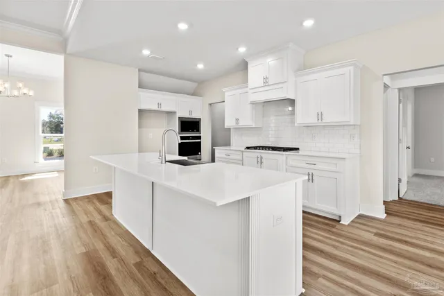 a kitchen with white cabinets sink and stainless steel appliances