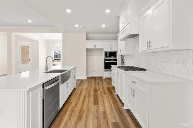 a kitchen with white cabinets appliances and a window
