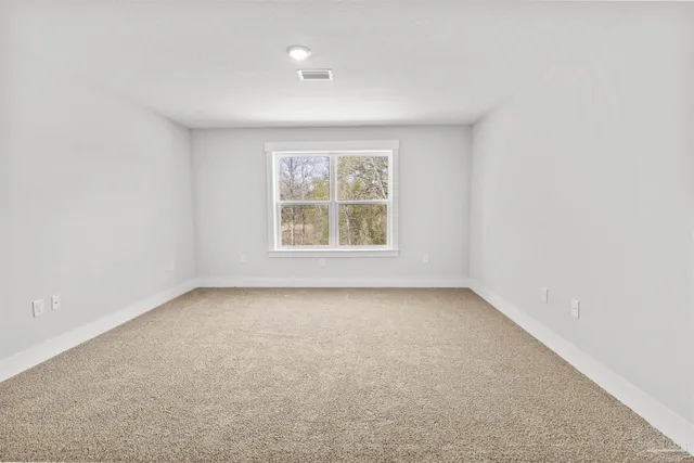 an empty room with a ceiling fan and windows