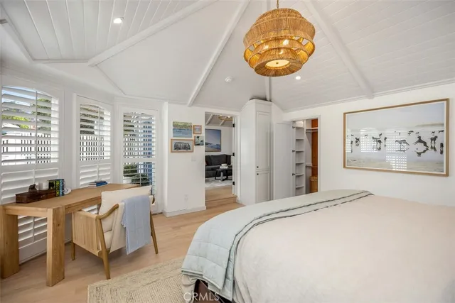 a spacious bedroom with a bed a table and a large window