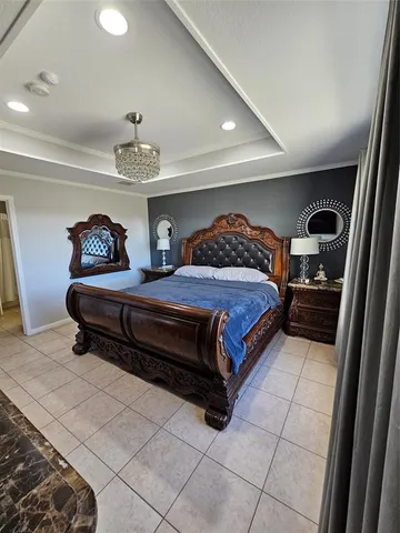 a spacious bedroom with a bed and a chandelier